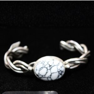 Sterling silver cuff bracelet with a single oval white howlite stone and twisted band on black background Sterling Silver White Howlite Cuff Bracelet