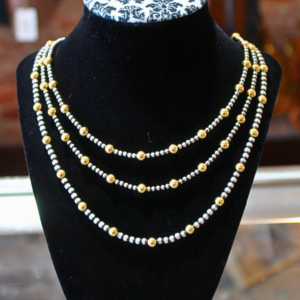Handcrafted Navajo Pearl necklaces with sterling silver beads and gold-filled accent beads displayed in layered lengths on a black velvet jewelry bust